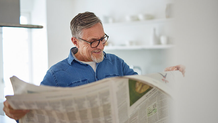 Mann liest im stehen Zeitung